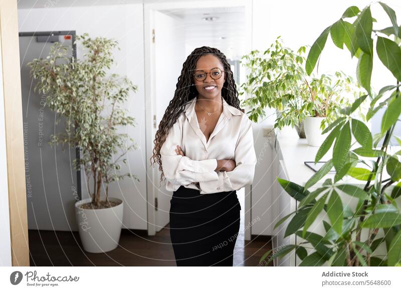 Portrait of happy black businesswoman standing arms crossed in office Businesswoman Happy Confident Success Formal Office Arms Crossed Smile Woman Cheerful
