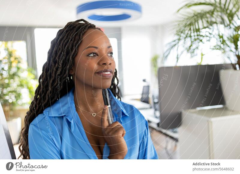 Thoughtful young African American businesswoman holding marker while standing in office Businesswoman Marker Office Presentation Brainstorm Smile Woman Work
