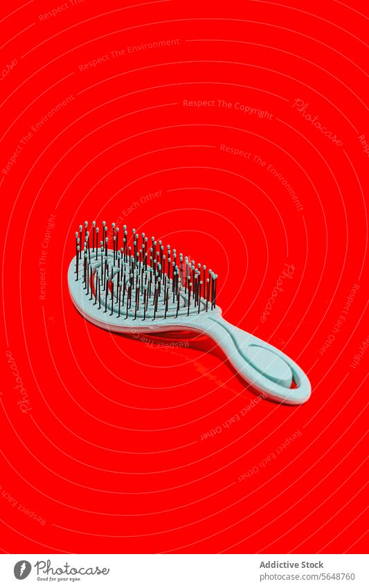 White hairbrush on a vibrant red background white contrast color beauty accessory grooming tool object single plastic bristle handle isolated fashion style care