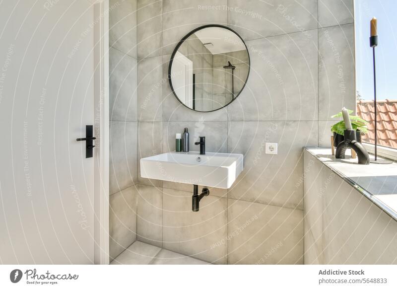 Interior of minimalist bathroom mirror sink window door circular mounted wall white closed modern sunlight candle copy space faucet reflection cabin tap
