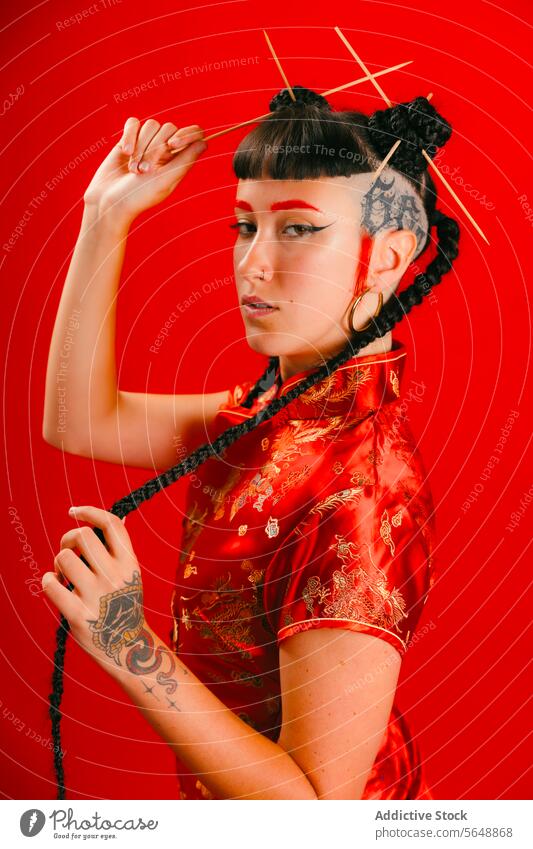Woman in traditional Asian attire posing on red background woman asian dress backdrop pose confidence fashion culture design young intricate style vibrant