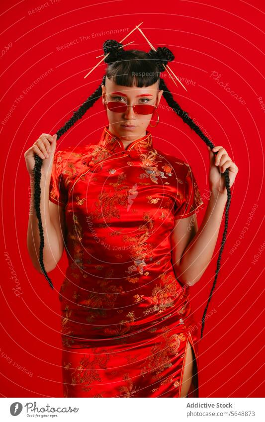 Woman in Traditional Chinese Dress with Playful Pose woman chinese dress red background playful pose fashion culture cheongsam elegance style asian oriental