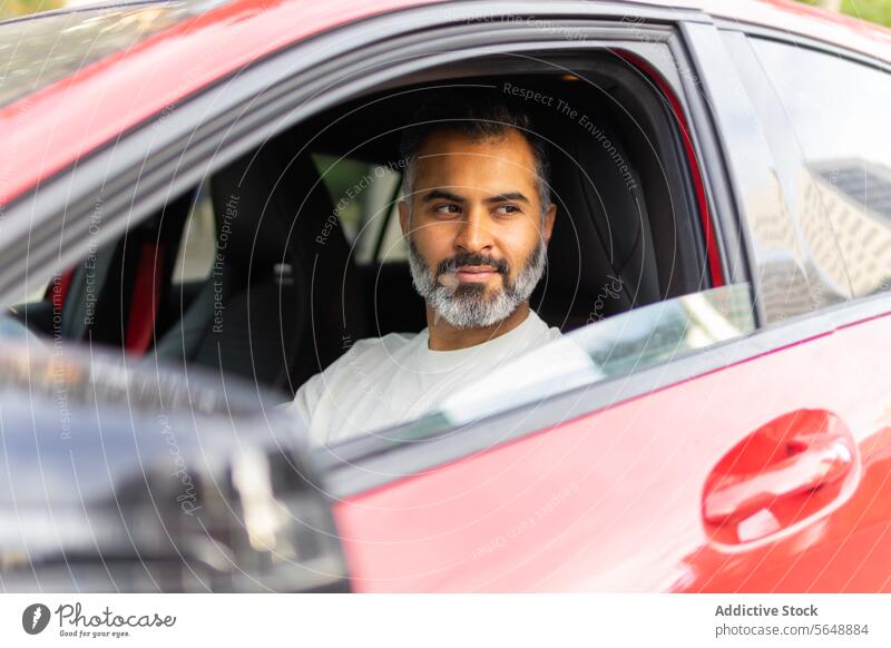 Indian man sitting on driver seat in car while looking away businessman automobile road trip vehicle ride transport male journey lifestyle entrepreneur beard