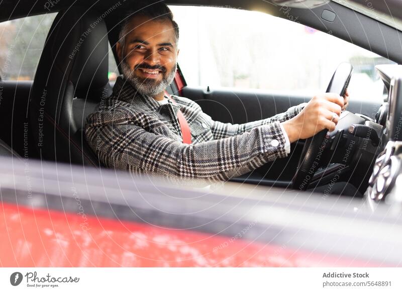 Smiling Indian man driving car while looking away businessman driver automobile road trip vehicle ride transport male journey seat lifestyle entrepreneur beard
