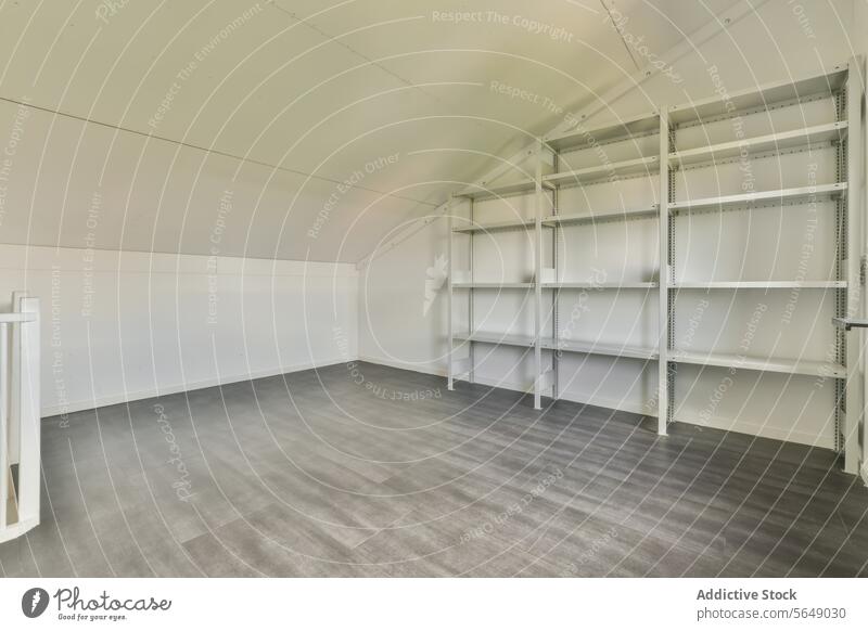 Empty attic room with metal storage shelves empty shelf white wall gray floor interior space clean uncluttered metal shelves storage solution home storage