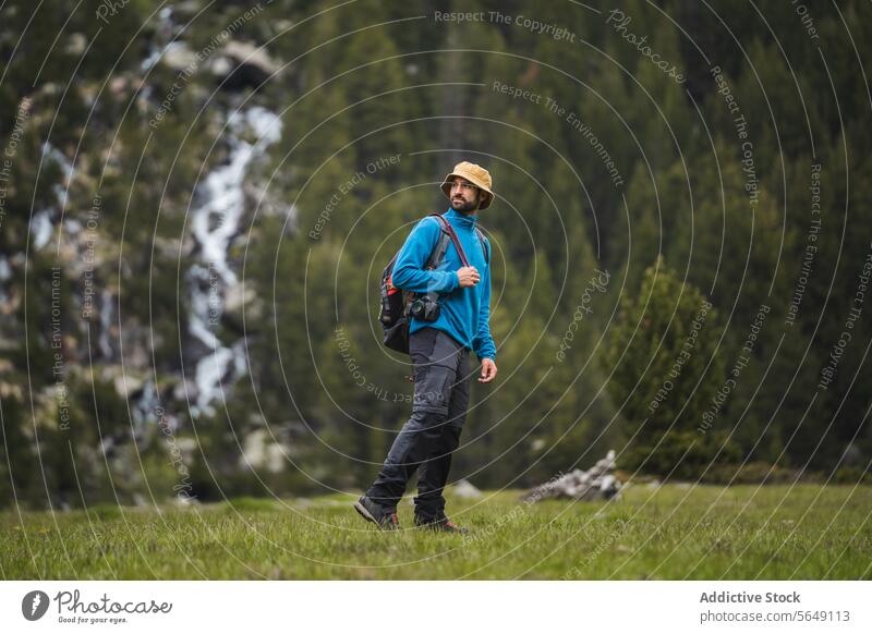 Male backpacker standing on grassy meadow in mountains Man Hiker Mountain Meadow Grass Adventure Nature National Park Explore Vacation Leisure Recreation