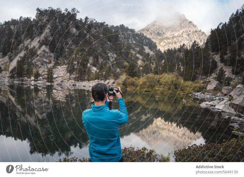 Anonymous man photographing majestic mountains using camera Man Tourist Take Photo Mountain Camera Lake Adventure Landscape Vacation Scenery Photographer Nature
