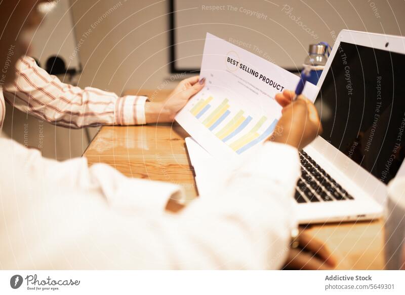 Crop employee analyzing data diagrams with laptop on desk in office chart analysis pc graph project business meeting strategy netbook coworker information