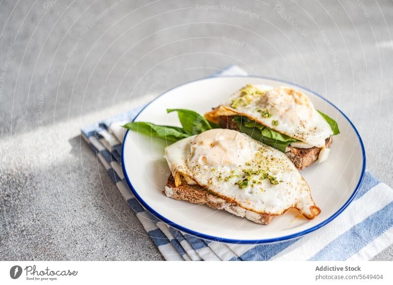 Tasty toast with spinach leaves fried eggs and pesto sauce for breakfast serve appetizing plate napkin food delicious yummy tasty fresh meal cuisine high angle