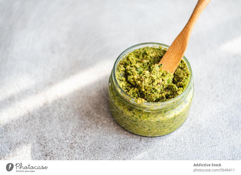 Glass jar of cashew mint pesto sauce on table prepare green healthy meal home fresh from above food healthy food vegan organic raw spoon kitchen recipe diet