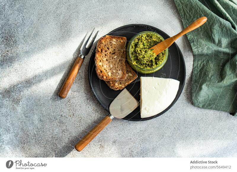 Plate with tasty rye bread cheese and pesto sauce plate homemade delicious bowl cutlery serve table food cuisine appetizing gourmet baked dish meal fresh fork