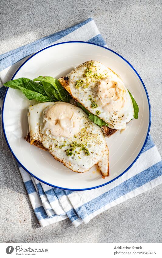 Tasty toast with spinach leaves fried eggs and pesto sauce for breakfast serve appetizing plate napkin food delicious yummy tasty fresh meal cuisine high angle