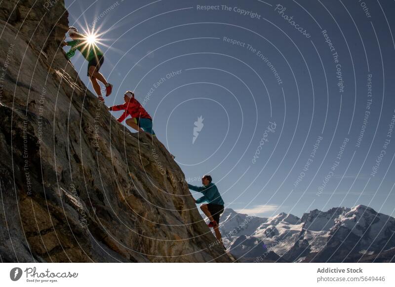 Two climber going up mountain ascent under sunburst adventure alpine climbing daylight endurance expedition high altitude high peak hiker hiking landscape
