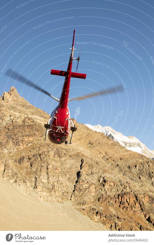 Mountain Helicopter Landing helicopter mountain landing ridge rugged red snow peaks blue sky clear altitude transport aerial flight rotorcraft aviation rescue