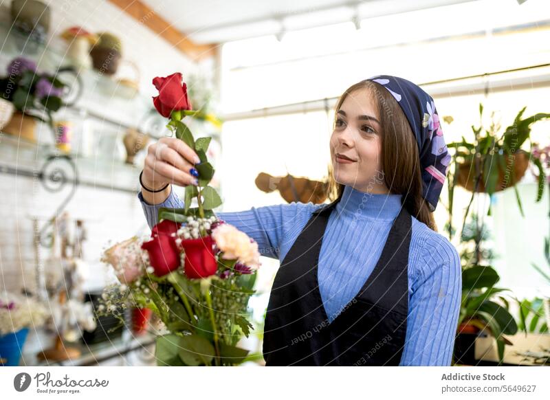 Happy florist making bouquet of flowers woman arrange rose create store work shop smile female young apron headscarf botany saleswoman workplace small business