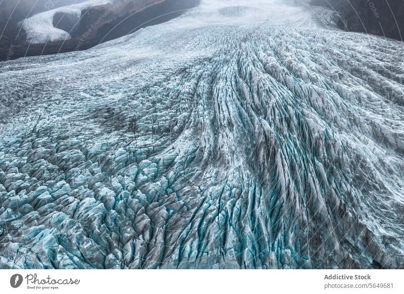A breathtaking view of the intricate icy crevasses and rugged terrain of Vatnajokull Glacier, set against a backdrop of mountains vatnajokull glacier iceland