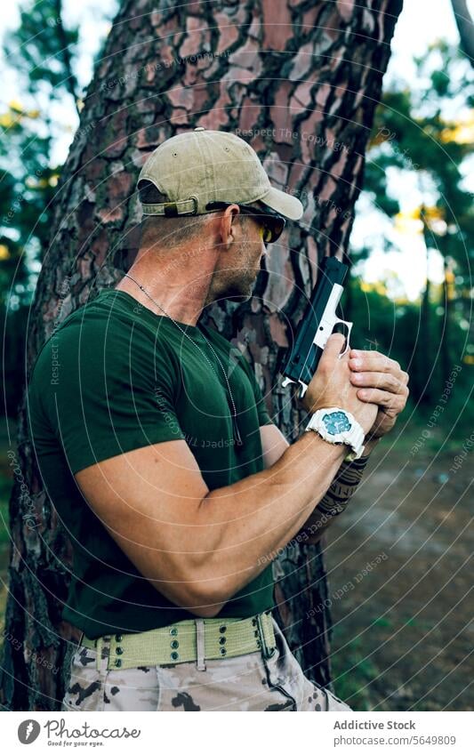 Side view of Military soldier with gun hiding behind tree against forest man commando handgun weapon army special force military blur mission firearm profession