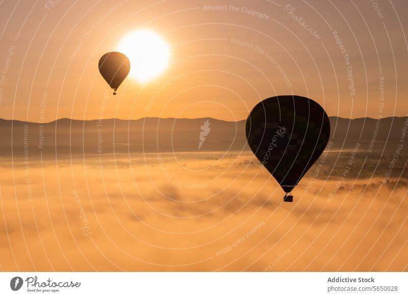 Hot air balloon floats in the golden sunrise sky above a mist-covered landscape hot air balloon Mexico flight Teotihuacan outdoor adventure transport