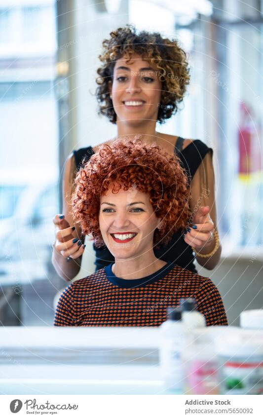 Joyful woman admires her new hairstyle at salon curly red hair hair salon smiling mirror beauty stylist happy hairdresser client customer reflection joy