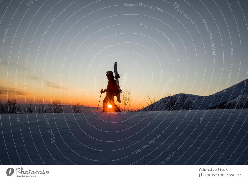 Person with skies and poles hiking on highland man sportswear active walk snow mountain clear sky sun beautiful sunset side view anonymous warm clothes helmet