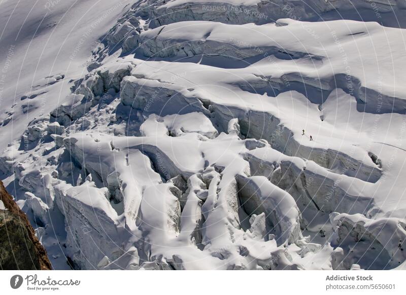 Aerial view of anonymous skiers in warm clothes Traversing a Snow-Covered Glacier in Zermatt, Switzerland glacier snow ice ridge trail alpine terrain
