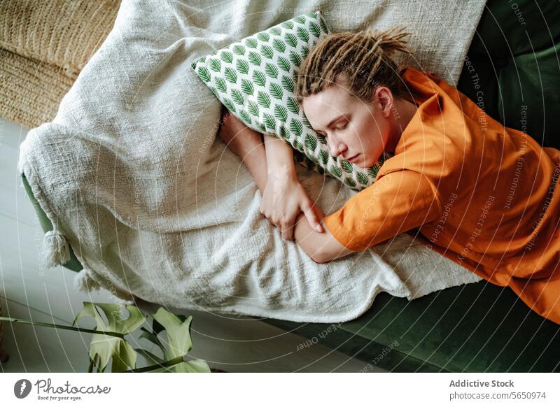 Young woman sleeping on comfortable sofa with cushion at home laptop apartment couch relax asleep nap pillow flat house tired female young lying eyes closed