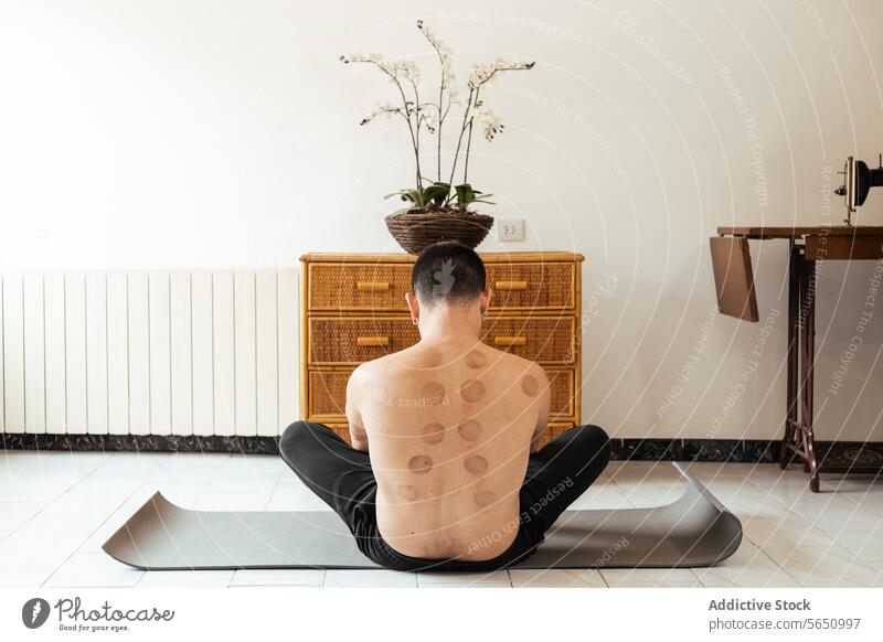 Faceless man in lotus posture during rehabilitation session stretch practice exercise lean mat anonymous sit abdomen workout training healthy lifestyle flexible