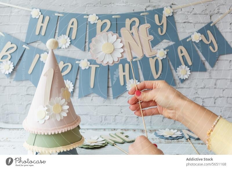 Birthday celebration with daisy theme and festive decorations birthday party banner hat person holding happy background flower event cheerful design hand paper