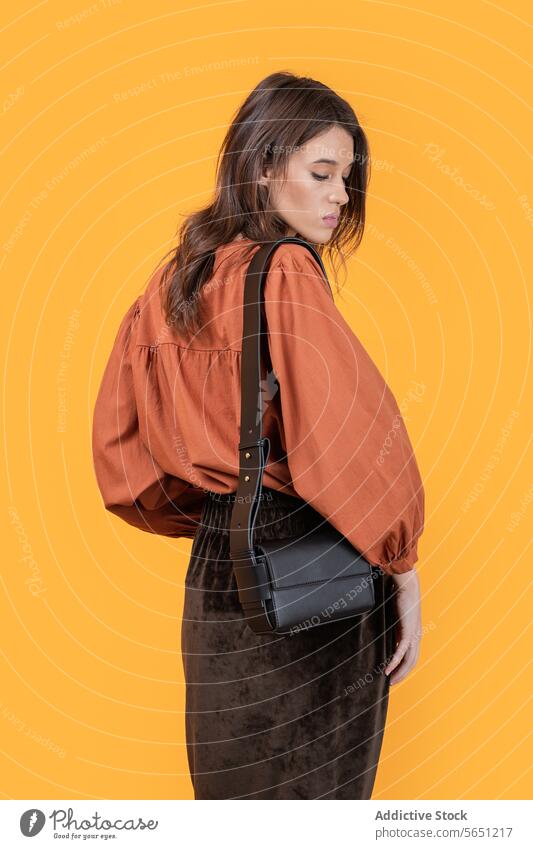 Stylish woman with purse isolated on yellow background confident trendy leather fashion holding elegance design attractive positive beautiful lifestyle