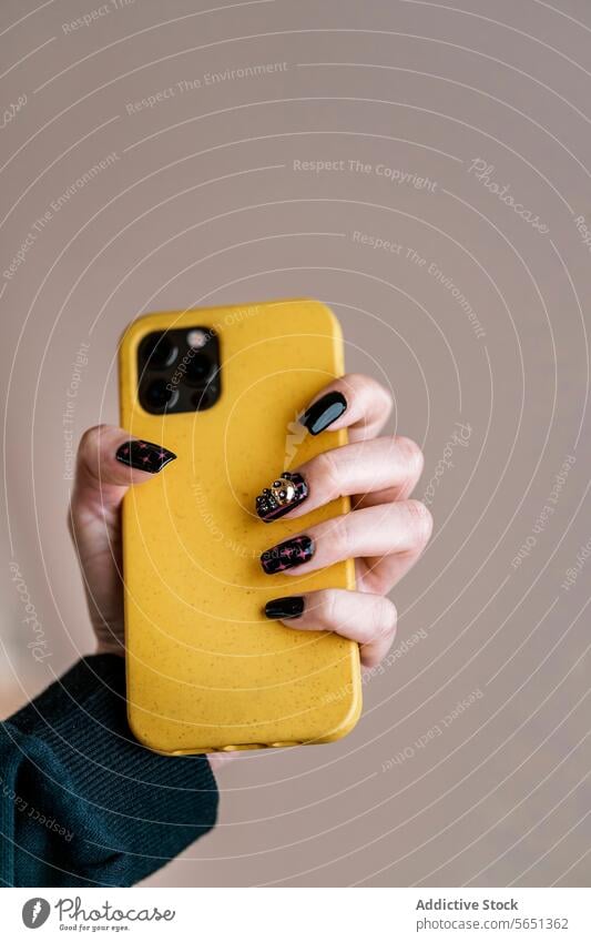 Crop woman with black nail art holding cellphone hand smartphone manicure nail polish creative yellow style device gadget modern mobile female paint body part