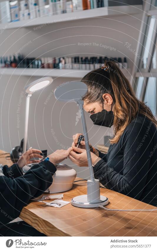 Crop woman getting nail manicure by beautician in salon women nail polish apply beauty procedure customer treat client service mask care professional master
