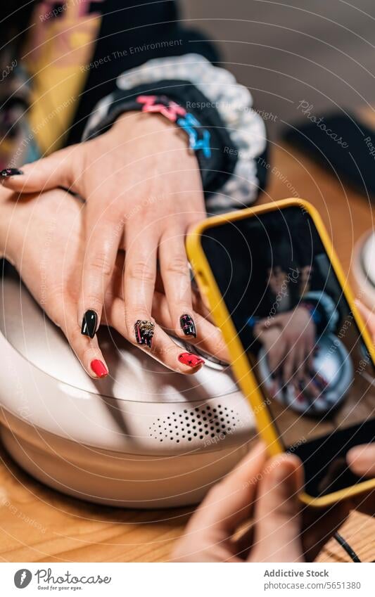 Crop manicurist taking picture of nail art on client in salon women smartphone take photo nail polish artwork design hand beautician using artist manicure