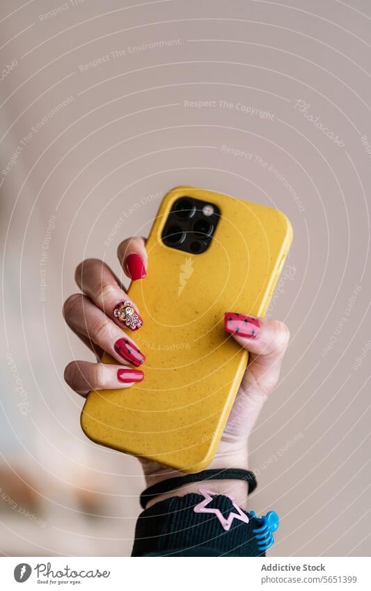 Crop woman with red nail art holding cellphone hand smartphone manicure nail polish creative yellow style device gadget modern mobile female paint body part
