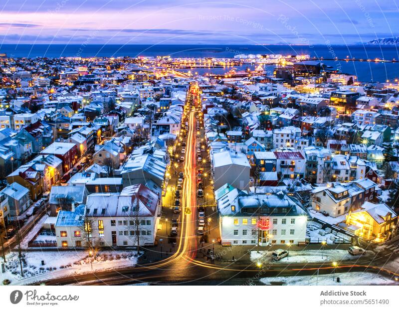Aerial view of Reykjavik at twilight with illuminated streets snow-covered rooftops and the ocean horizon in the distance aerial view Iceland cityscape urban