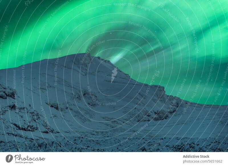 Picturesque view of mountain range covered with snow against blue sky with green aurora borealis in winter green sky picturesque cold ridge northern polar
