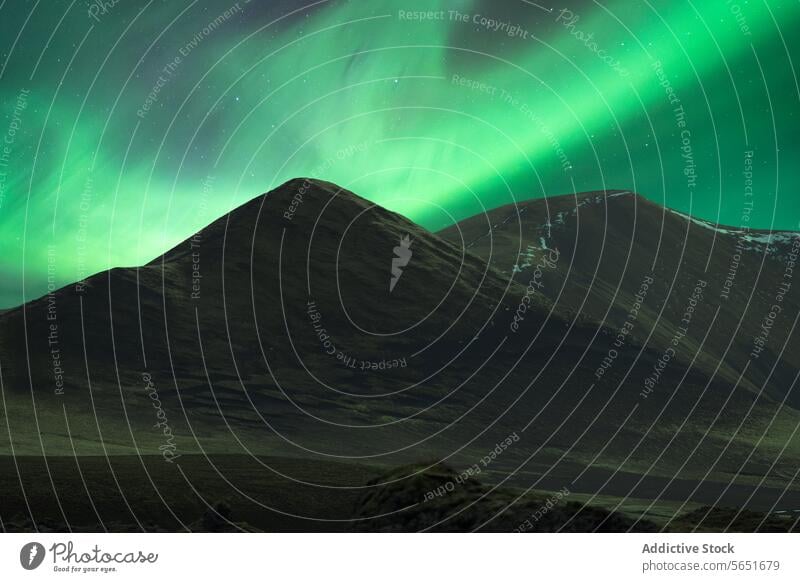 Smooth, snow-capped mountain under the northern lights in Iceland aurora borealis night green sky natural wonder landscape outdoor smooth scenic travel