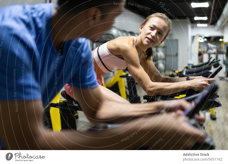 Fitness enthusiasts using stationary bikes at the gym fitness spinning workout exercise active lifestyle indoor center sport health endurance training male