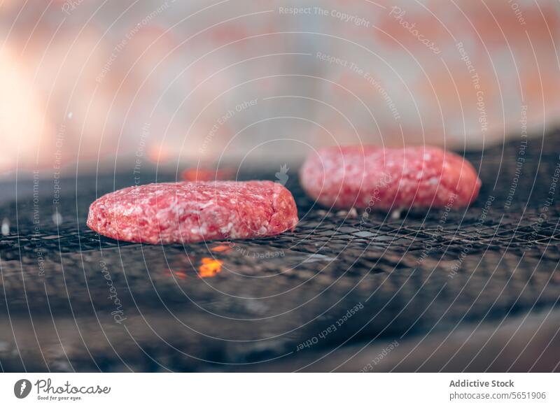 Raw burger patties grilling over charcoal flames patty raw cook barbecue meat glowing essence hamburger cooking outdoor gourmet bbq ground beef food summer heat