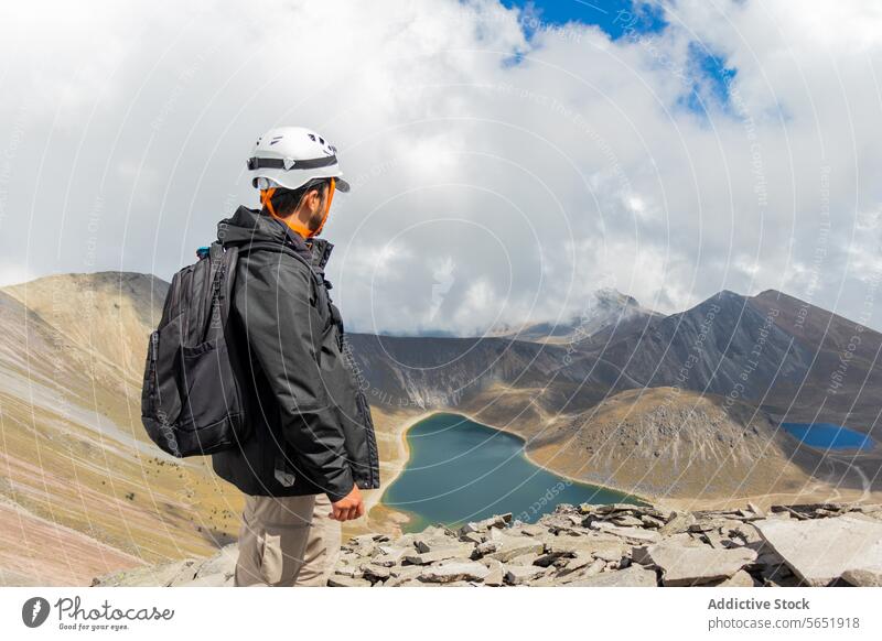 Adventurer gazing at lakes in Nevado de Toluca, Mexico adventure hiker safety gear mountain nevado de toluca mexico crater sky cloudy overlook terrain outdoor