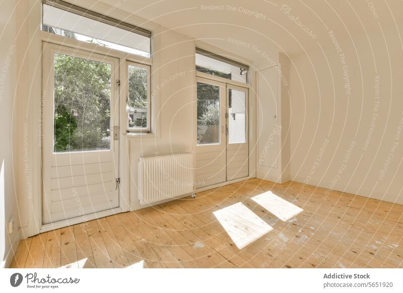 Empty room with door and window sunlight bright radiator white paint stain dirt hardwood floor empty modern apartment home house wall renovation unfinished