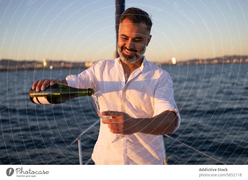Smiling man poring wine in glass wineglass pour yacht sea cruise enjoy nature happy alcohol drink water smile beverage refreshment glad bottle ocean content