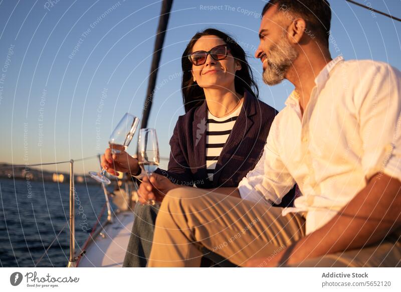 Smiling couple clinking wineglasses in yacht against sea love romantic toast ocean smile happy beach alcohol date resort drink cheers enjoy pleasure seascape