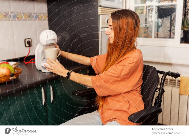 Inclusive living - woman in wheelchair making coffee at home machine kitchen accessibility independence preparation drink household appliance interior cozy