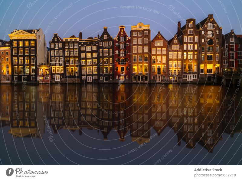 The golden hour reflects on Amsterdam's iconic canal houses, mirrored perfectly in the still water reflection Netherlands sunset architecture cityscape Dutch