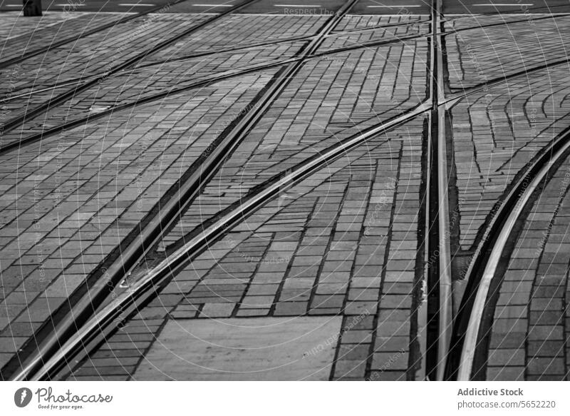 Complex network of tram tracks crisscrossing on cobblestone streets in black and white, Rotterdam complex urban texture pattern intersection city transportation