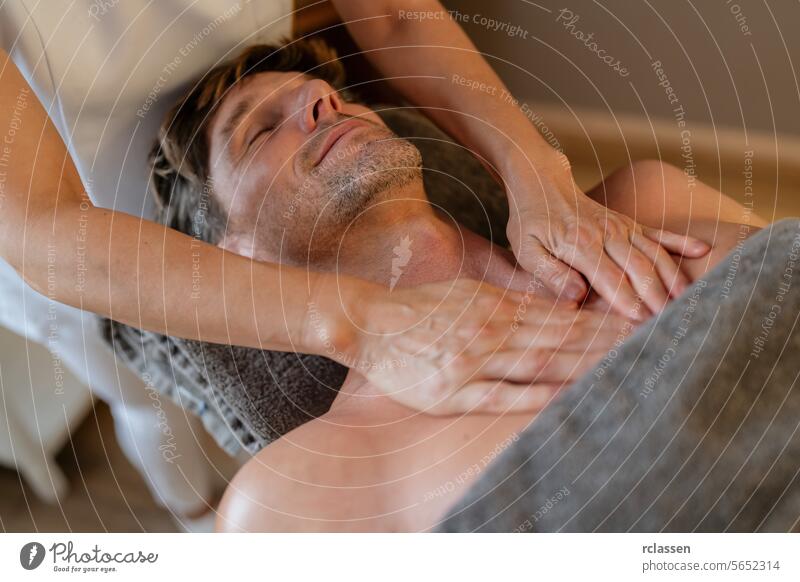 Man relaxing during a chest massage at a spa with a serene expression. Wellness Hotel Concept image. hotel massage oils man man relaxing neck massage relaxation