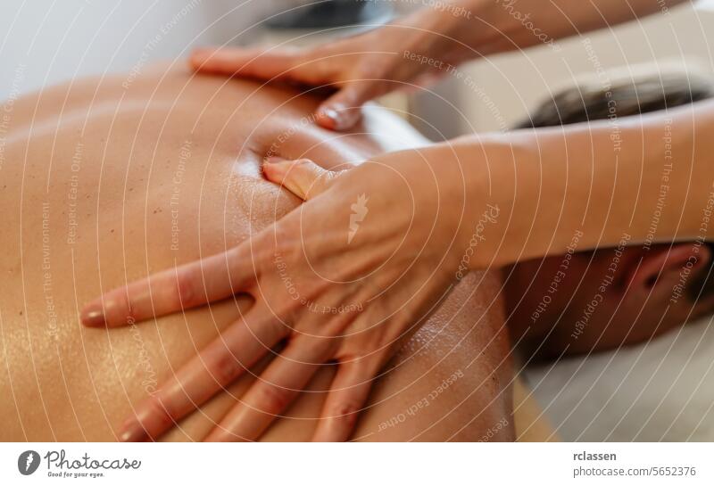 Close-up of a therapist giving a neck and shoulder massage to a man lying down hotel massage oils physiotherapist asian back massage neck massage relaxation