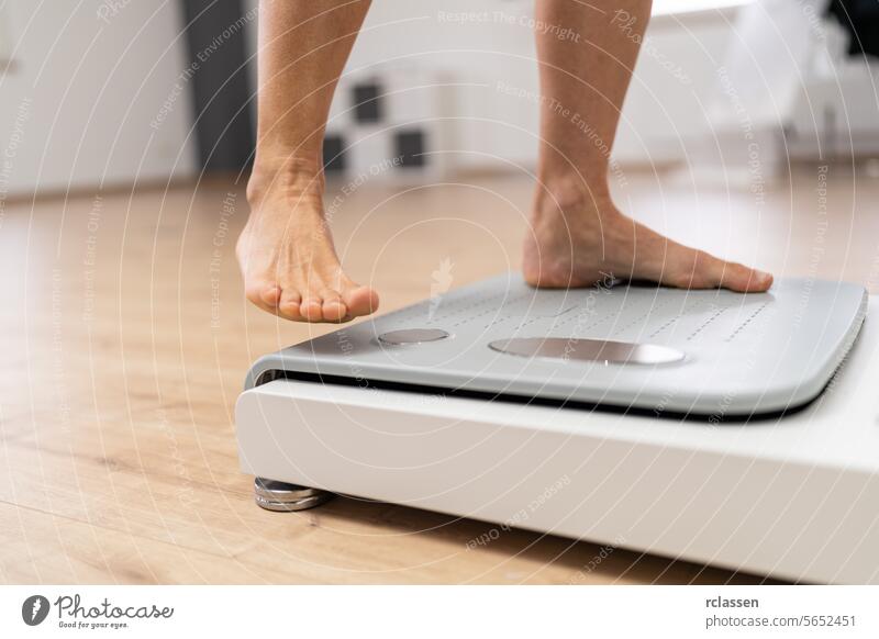 bare feet stepping onto a modern body composition scale in a fitness or medical setting during Inbody test analyzing bioelectric technology computer inbody fat