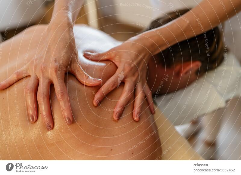 Close-up of a massage therapist applying pressure on a client's back. beauty salon Wellness Hotel Concept image clinic hotel massage oils physiotherapist asian
