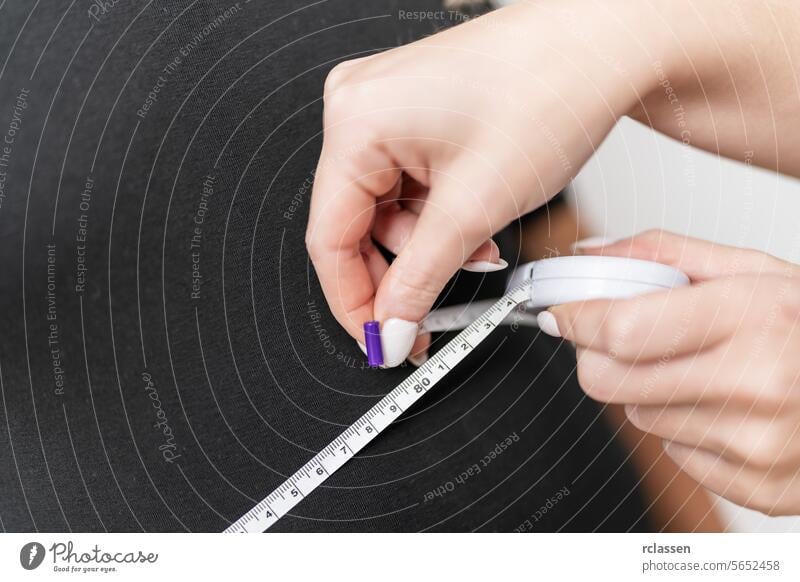 Hands using a measuring tape on a black female torso for a health analysis. Fitness and health concept image fat slim diet weight loss precision fitting